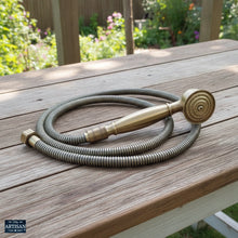 Load image into Gallery viewer, Brass Handheld Shower Sprayer | Show this close up on a old farmhouse table in the garden with 2k high quality.